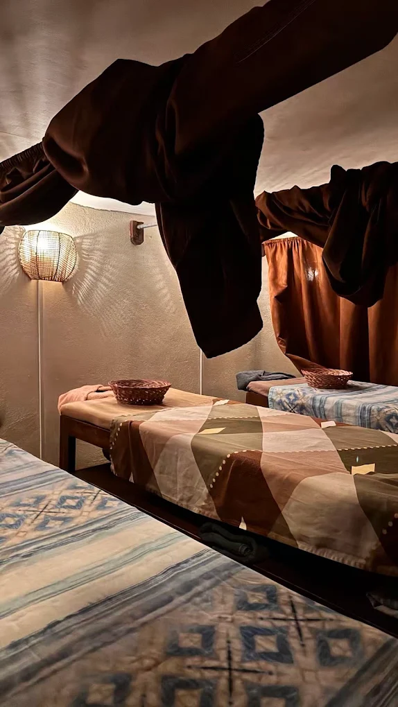 Massage beds with patterned covers and warm lighting at Nature Spa